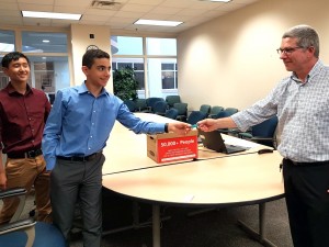 Nathan Koh and Yousef Emara present 50,000 signatures to MDEQ's Matt Gamble.